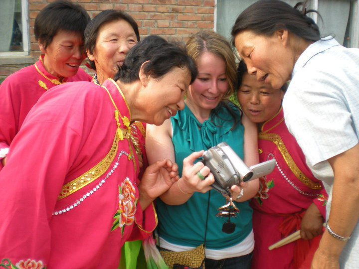 Arkansas blogger, Amy, at a Heifer Village in Beijing China with a group of ladies viewing camera photos