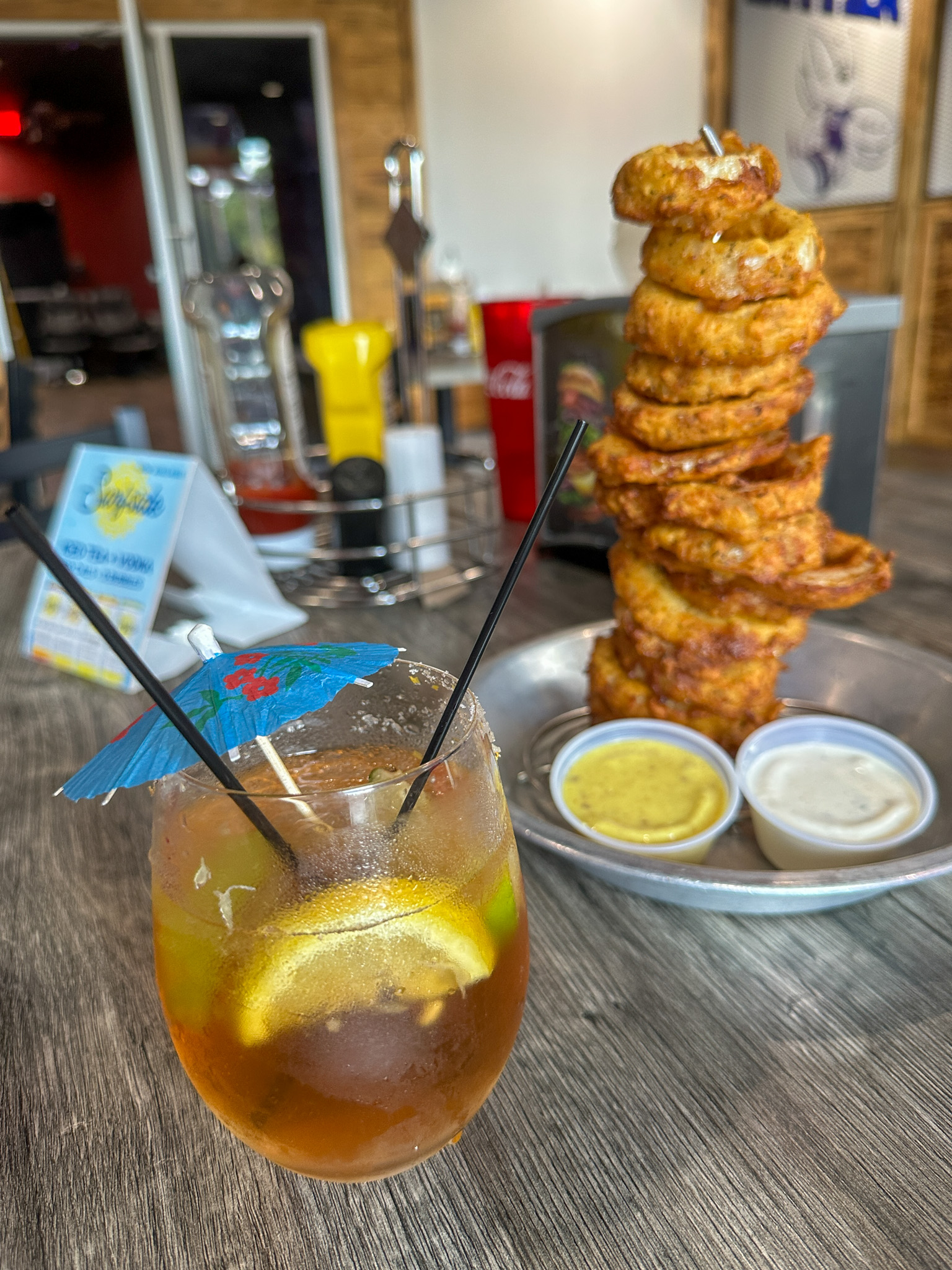 a glss with an umbrella for taking drink orders in English post