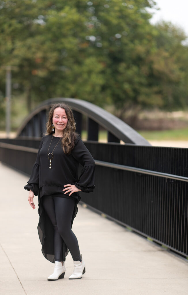 Arkansas lifestyle blogger and ESL coach, Amy Gramlich, stands in front of bridge in Little Rock