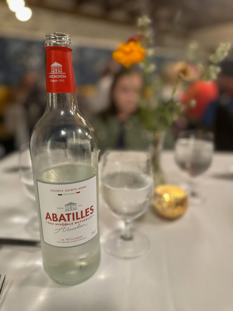 mineral water and glasses on table for taking drink orders in English